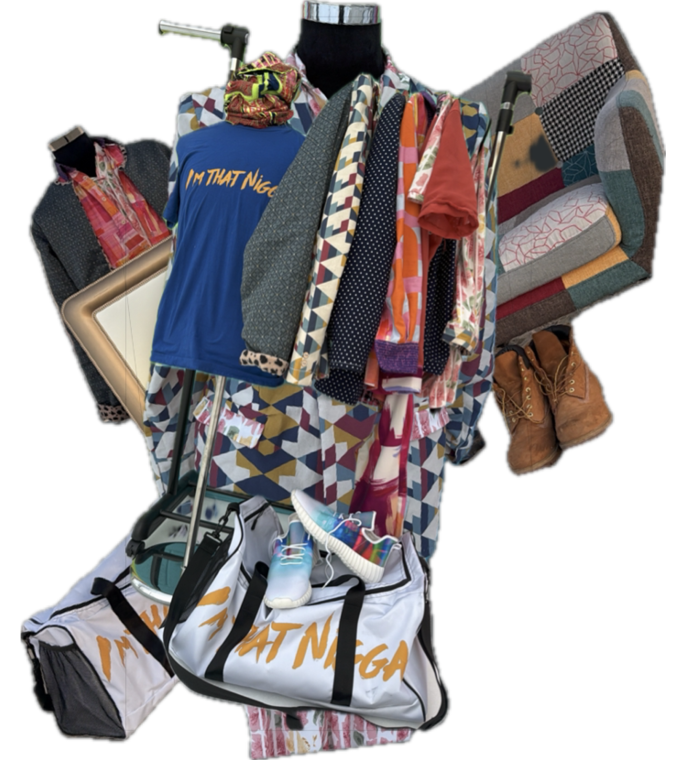 A mannequin dressed in colorful patterned clothing is surrounded by various garments, a framed picture, a pair of brown boots, and two white bags with orange text. Description generated by AI